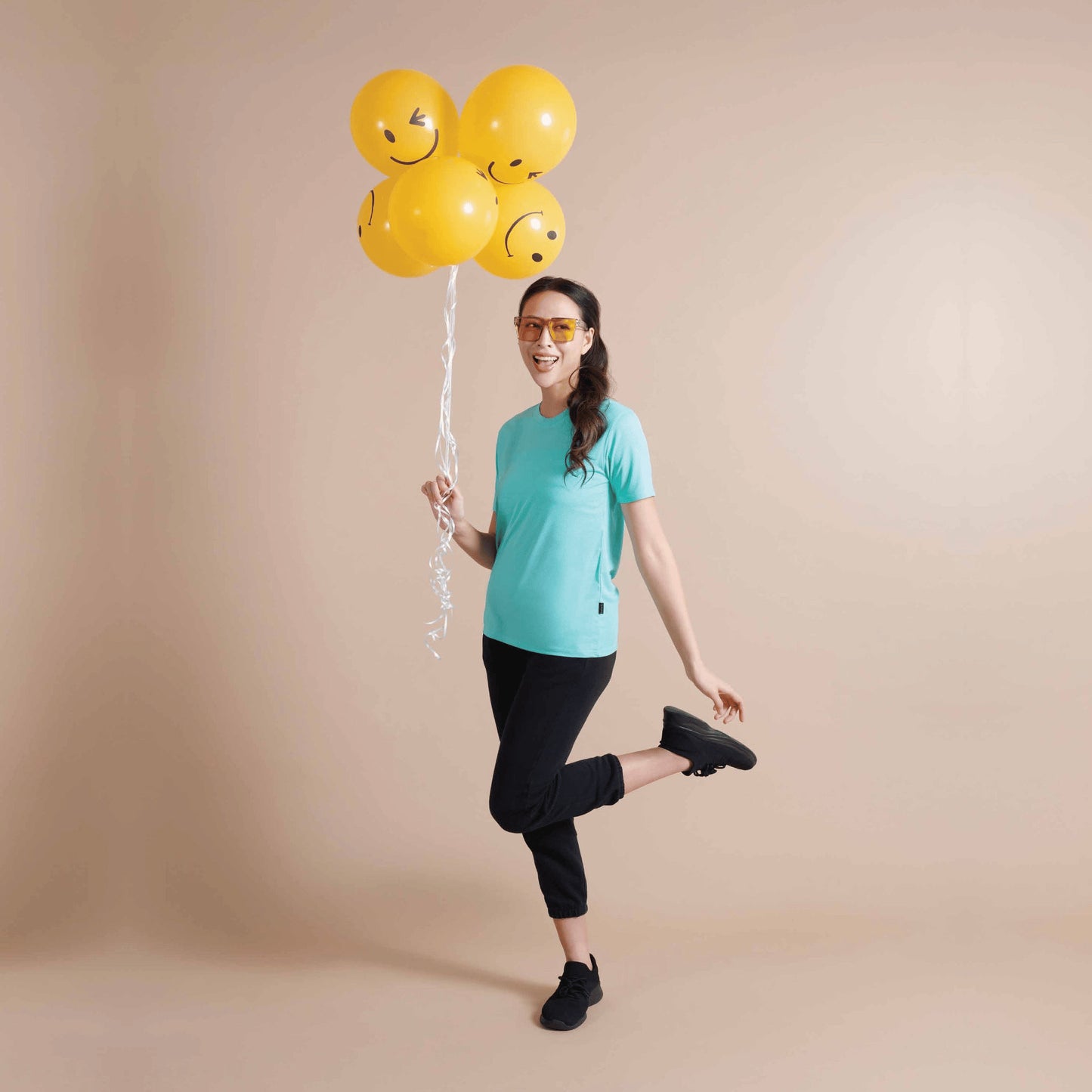Woman wearing the QD66 unisex check jacquard antibacterial t-shirt in Tiffany Blue, holding smiley balloons